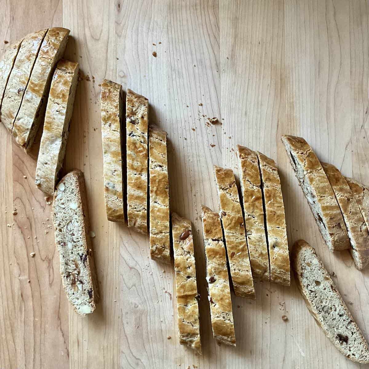 Sliced biscotti on a wooden board ready for a second bake.