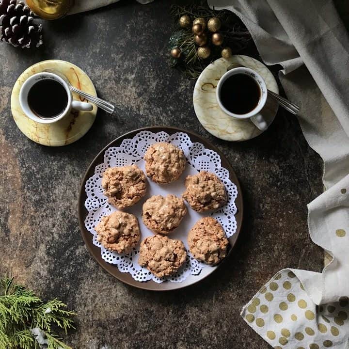 An overhead shot of a platter of brutti ma buoni cookies along side 2 espressos.