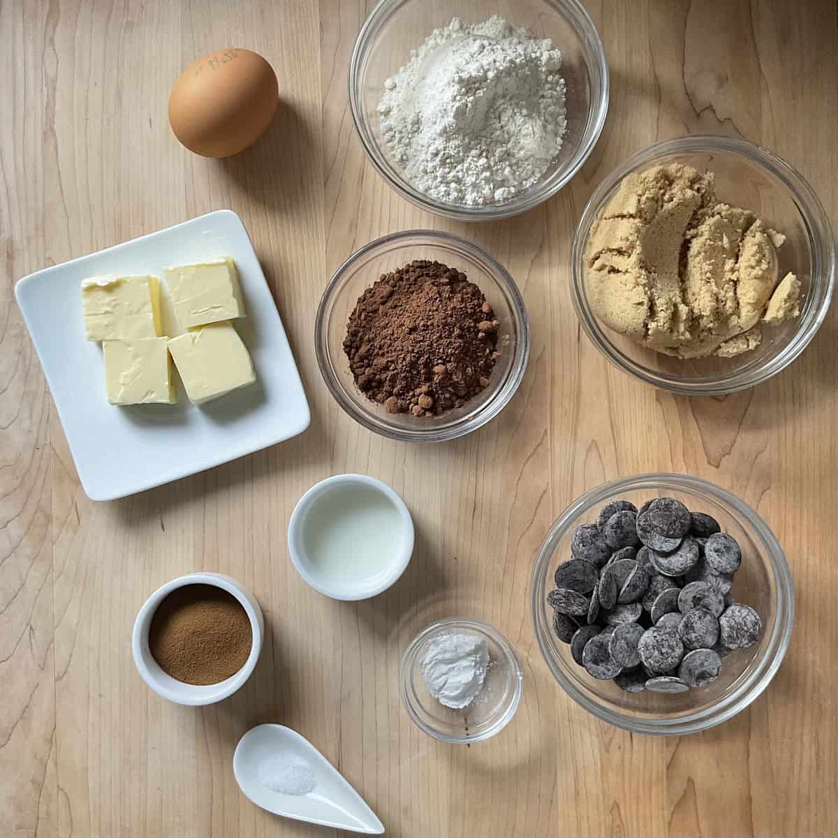 Ingredients to make chocolate crinkle cookies on a wooden board.