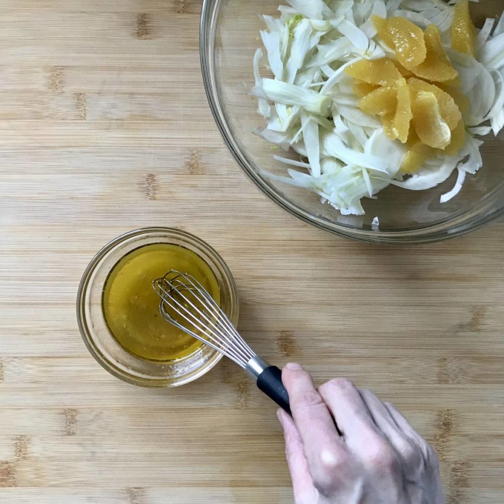 A citrus vinaigrette is being whisked together.