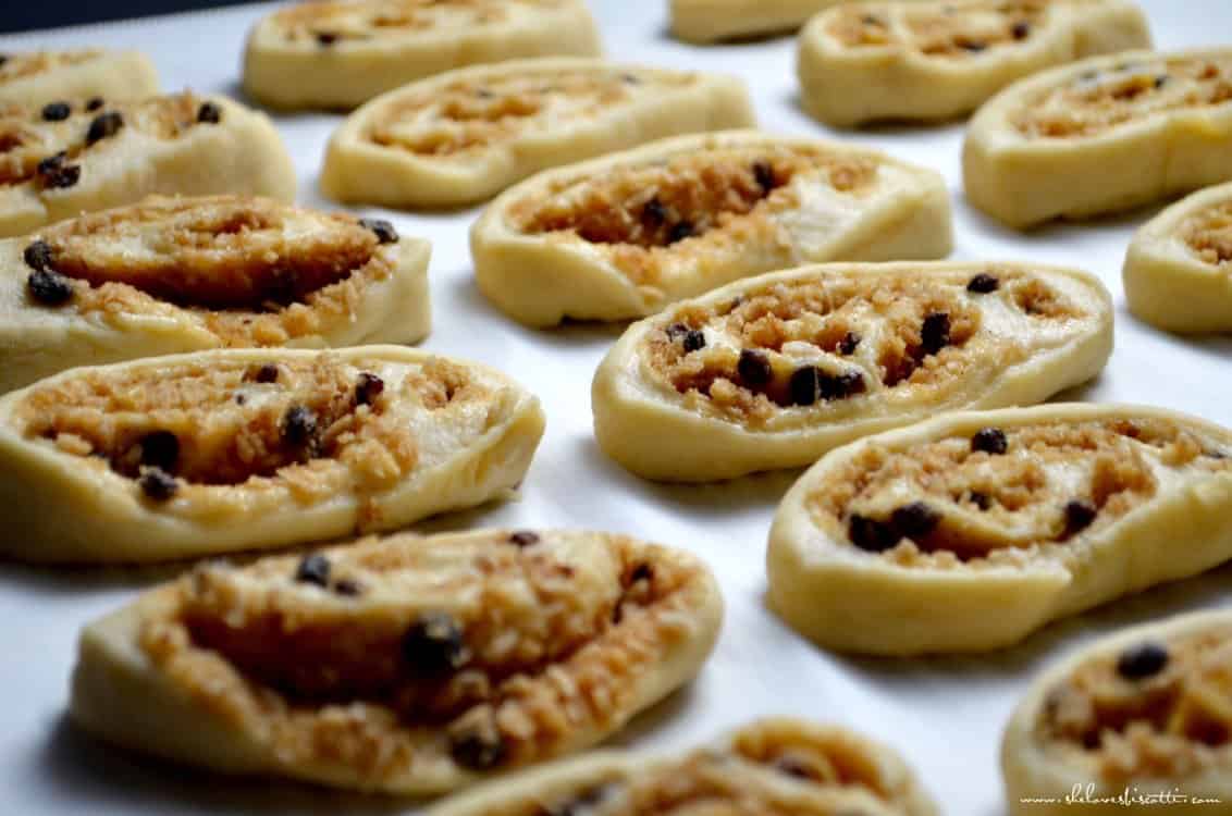 Sliced pets de soeur shown on a baking sheet.