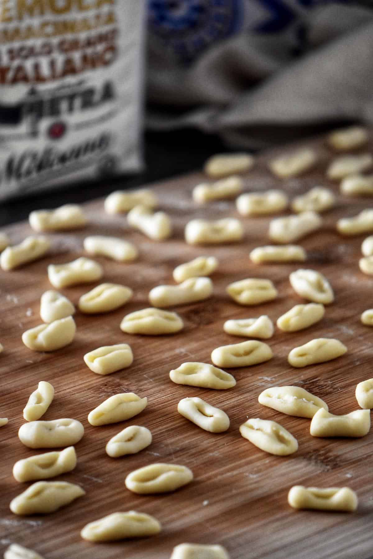 Freshly made cavatelli on a wooden board.