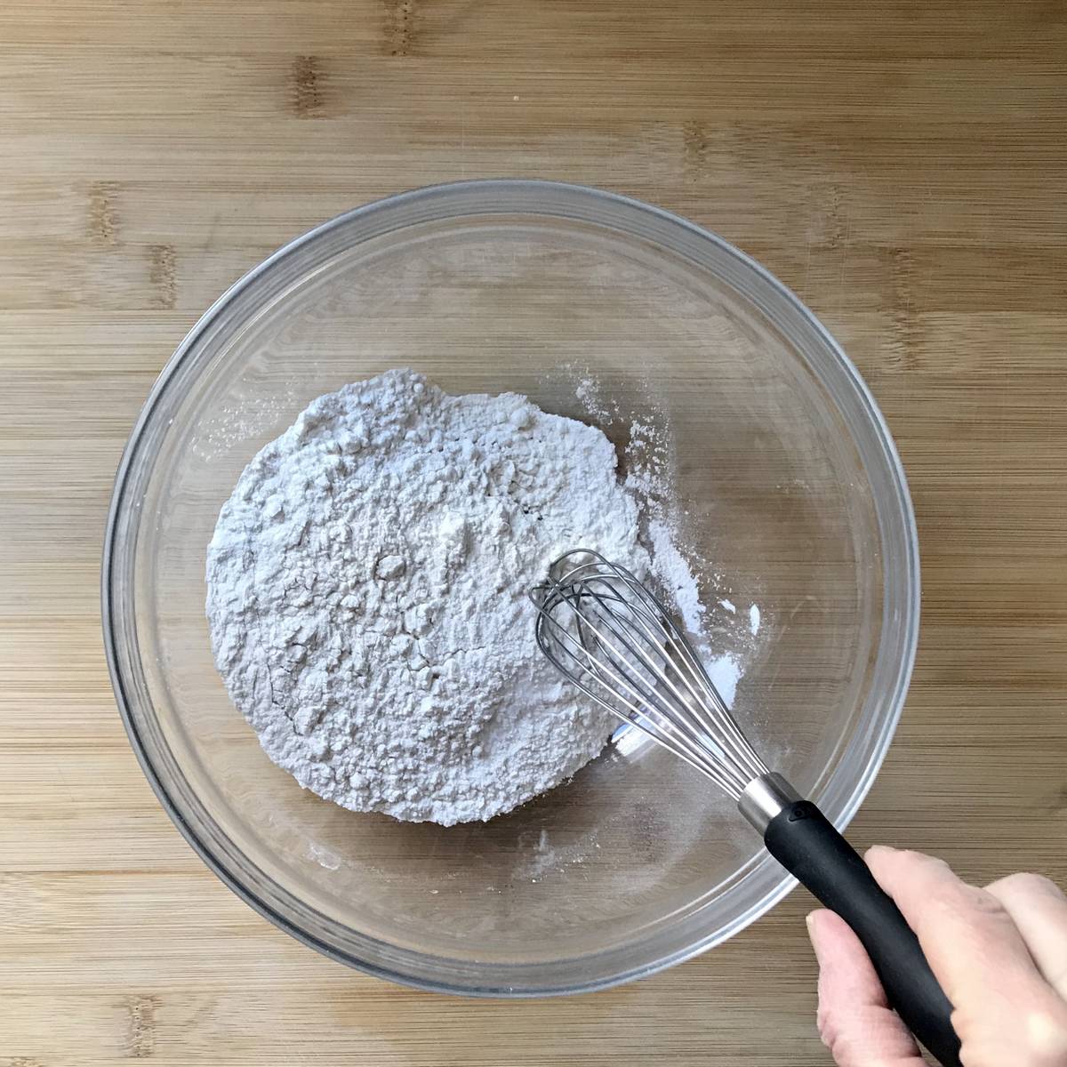 The dry ingredients to make pancakes are whisked together.