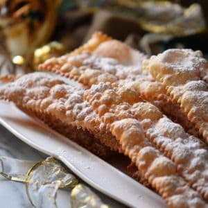 A close up shot of the dozens of tiny air pockets of this Italian fried Italian cookie (crostoli) can be seen.