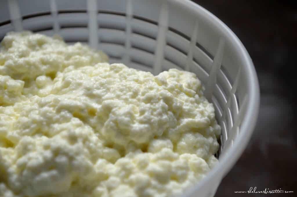 A close up shot of creamy ricotta cheese in a cheese basket.