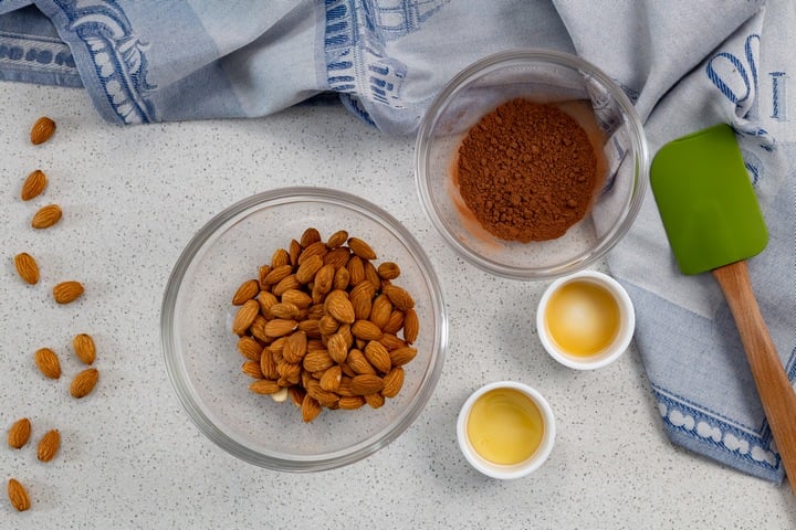 The ingredients required to make cocoa almonds in bowls.