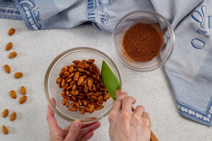 The honey mixture being combined with the almonds.