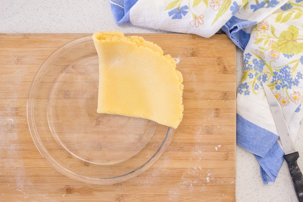 The pie dough or pasta frolla is placed in a glass pie plate.