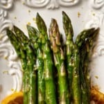 An overhead shot of sauteed asparagus garnished with lemon zest.