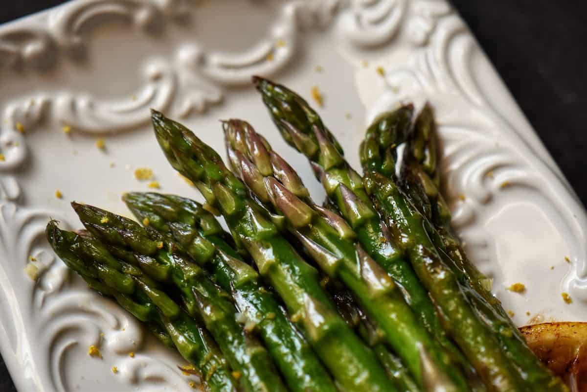 An overhead shot of asparagus tips garnished with lemon zest.