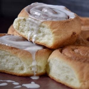 Stacked cinnamon rolls on a sheet pan.