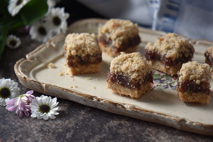 A side shot of the thickness of the date filling sandwiched by the oat crumble.