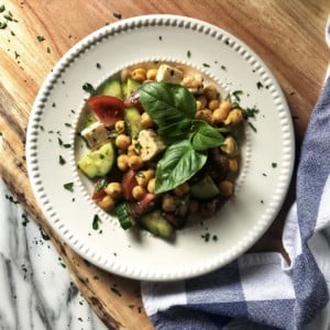 An overhead shot of a chickpea salad in a white round plate.