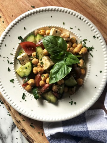 An overhead shot of a chickpea salad in a white round plate.