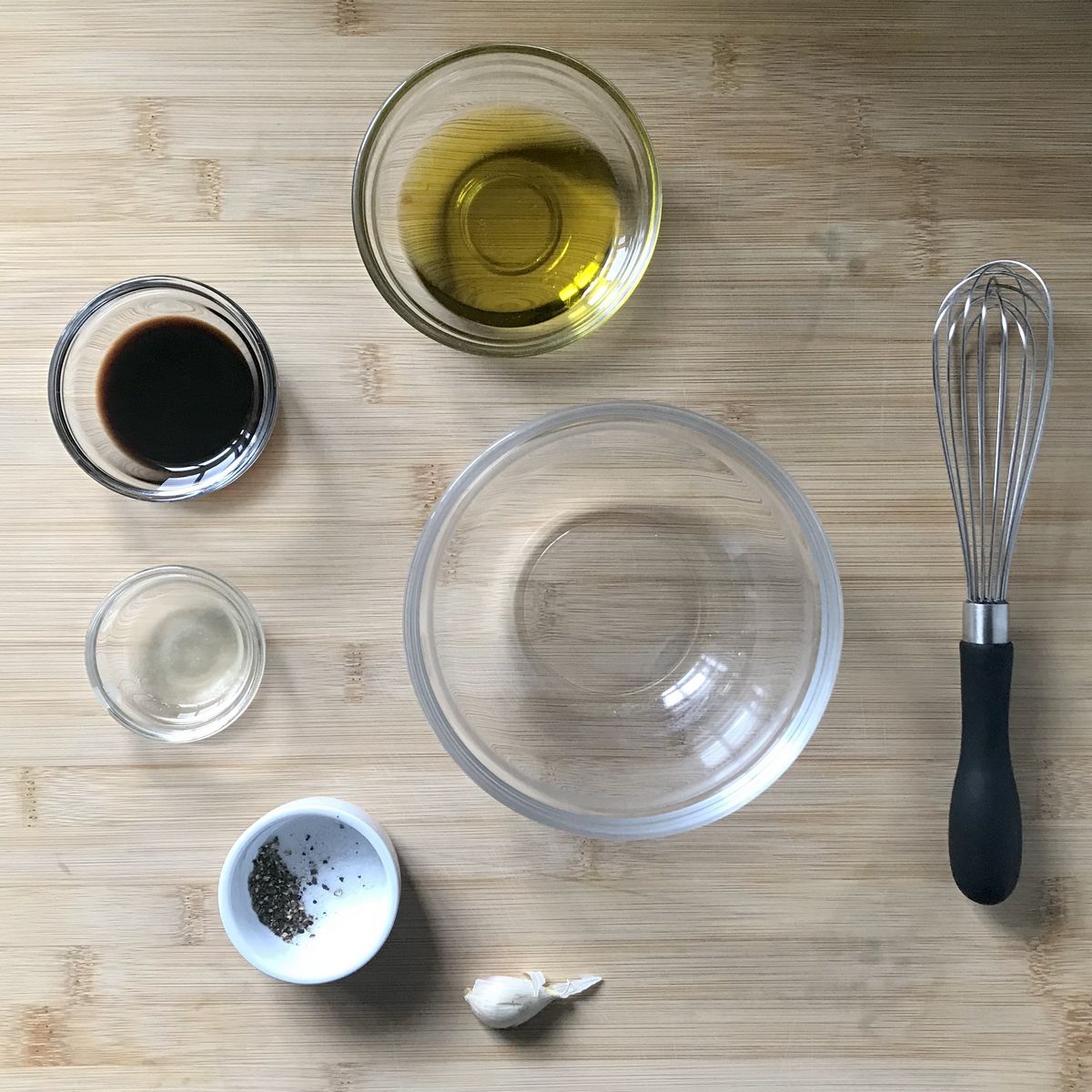 The ingredients to make the vinaigrette in bowls.