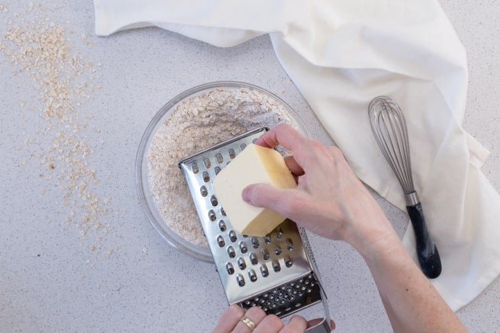 Grated butter in the process of being added to the oat crumble mixture.