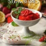 Macerated strawberries in a white dish, surrounded by fresh strawberries.
