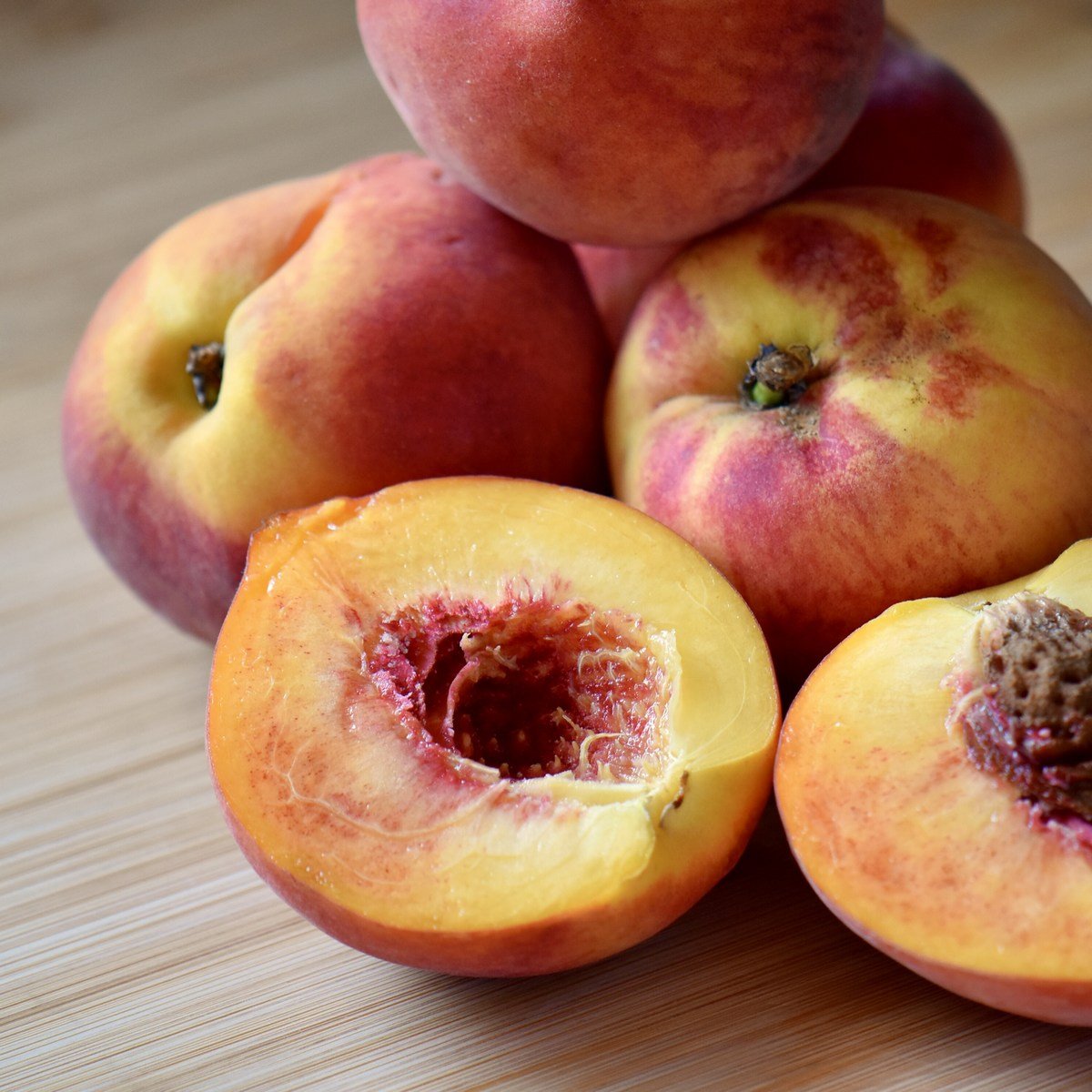 Peaches on a wooden cutting board.