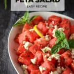Cubes of watermelon salad with feta and mint in a large oval platter.