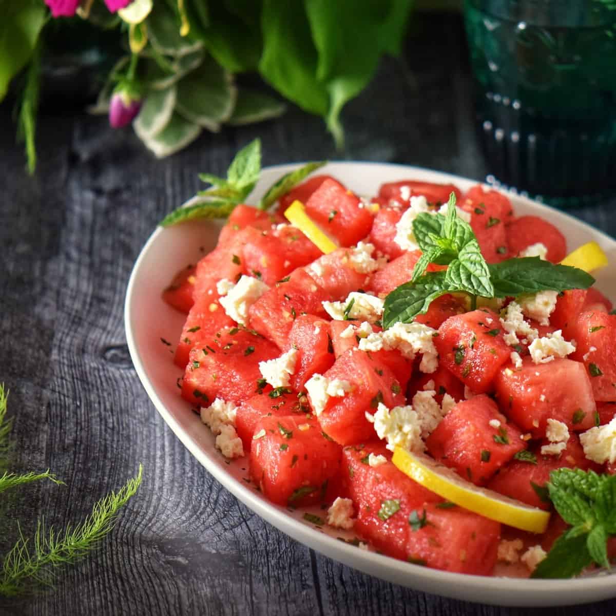 Cubes of watermelon salad with feta and mint in a large oval platter.