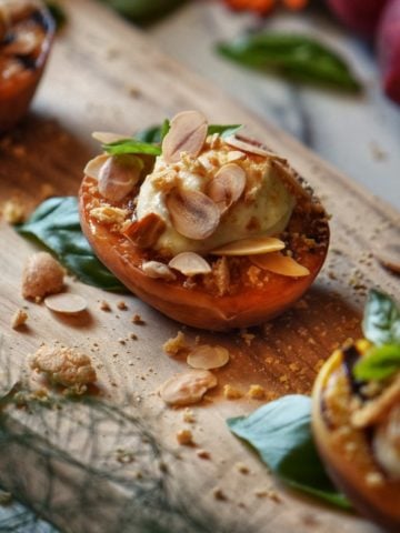 Grilled peaches garnished with ricotta, almonds and crushed amaretti cookies.