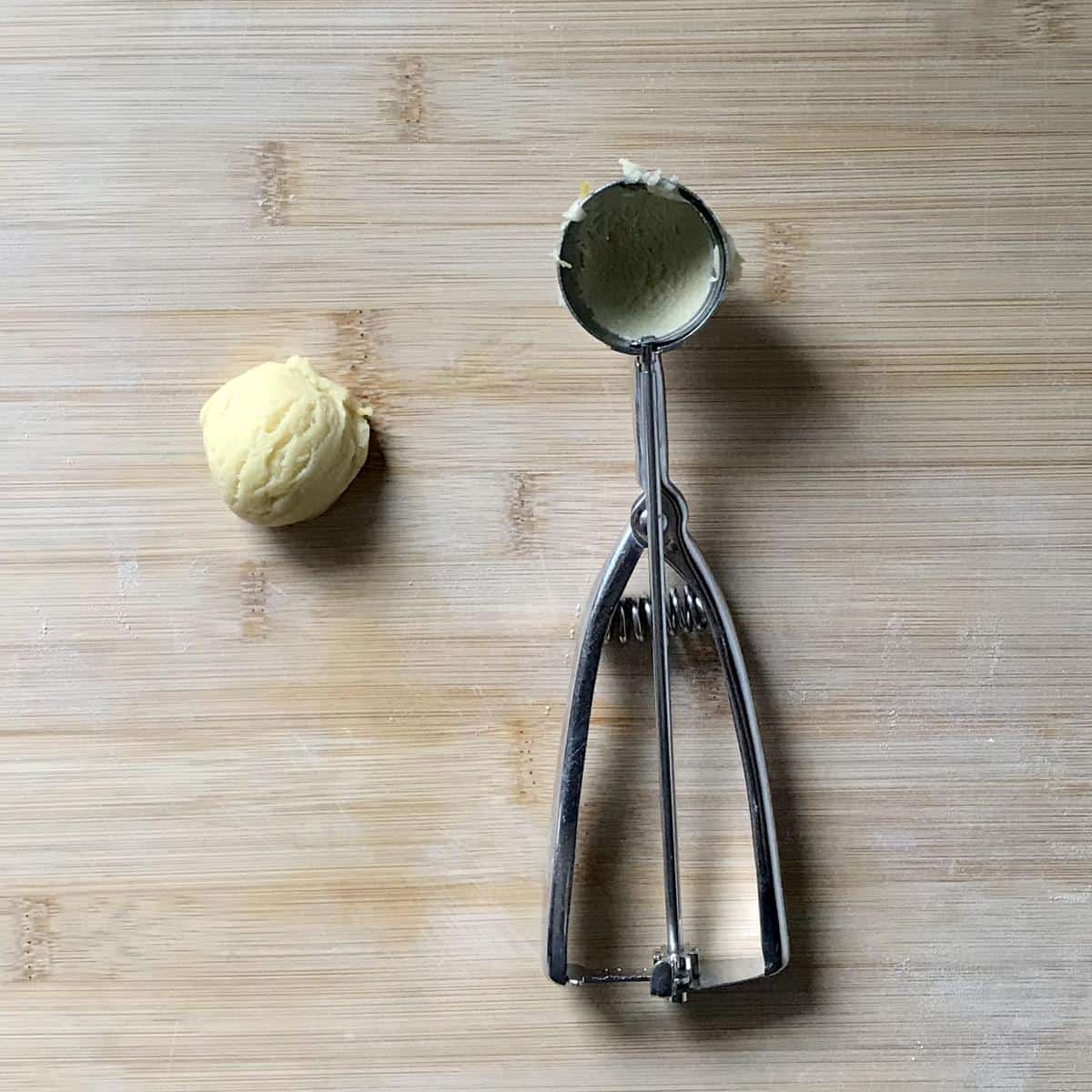 A small scoop of cookie dough on a wooden board. 