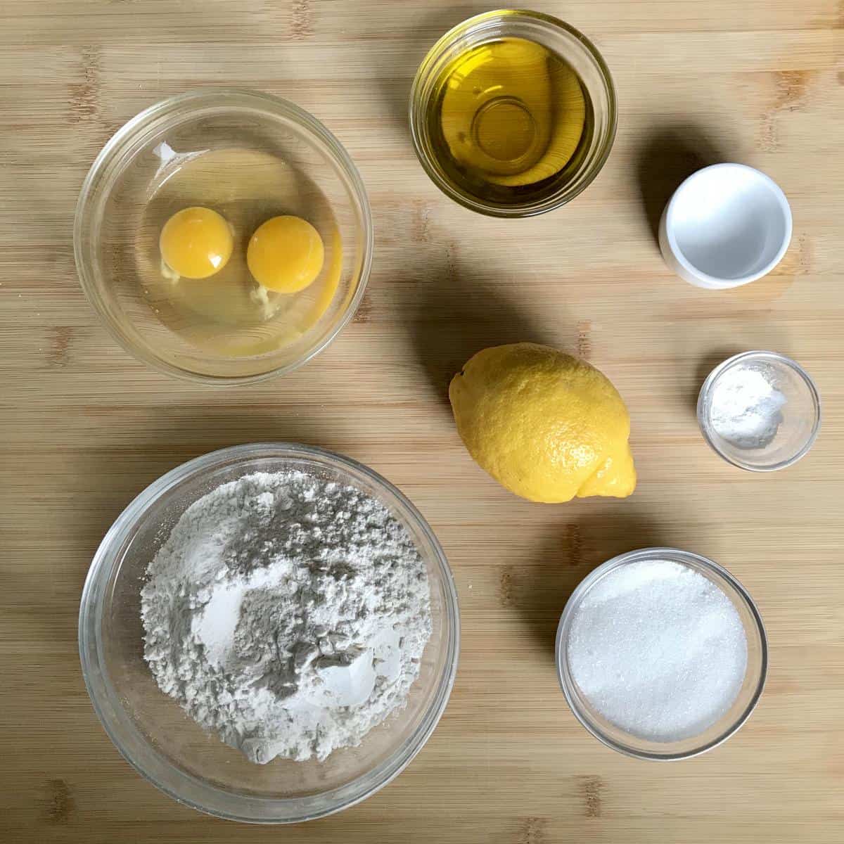 Wet and dry ingredients in separate bowls on a wooden surface.