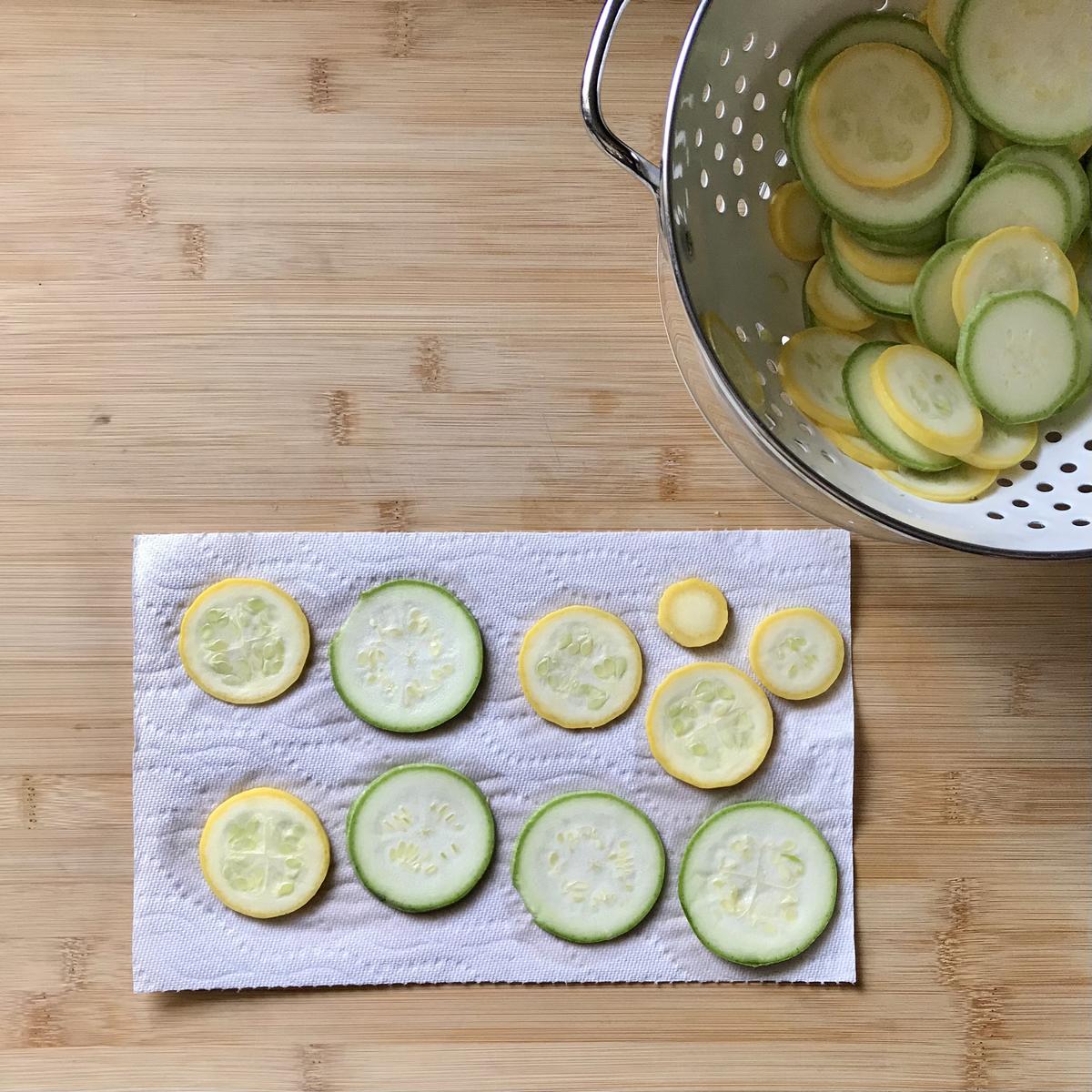 Sliced zucchini on a paper towel.
