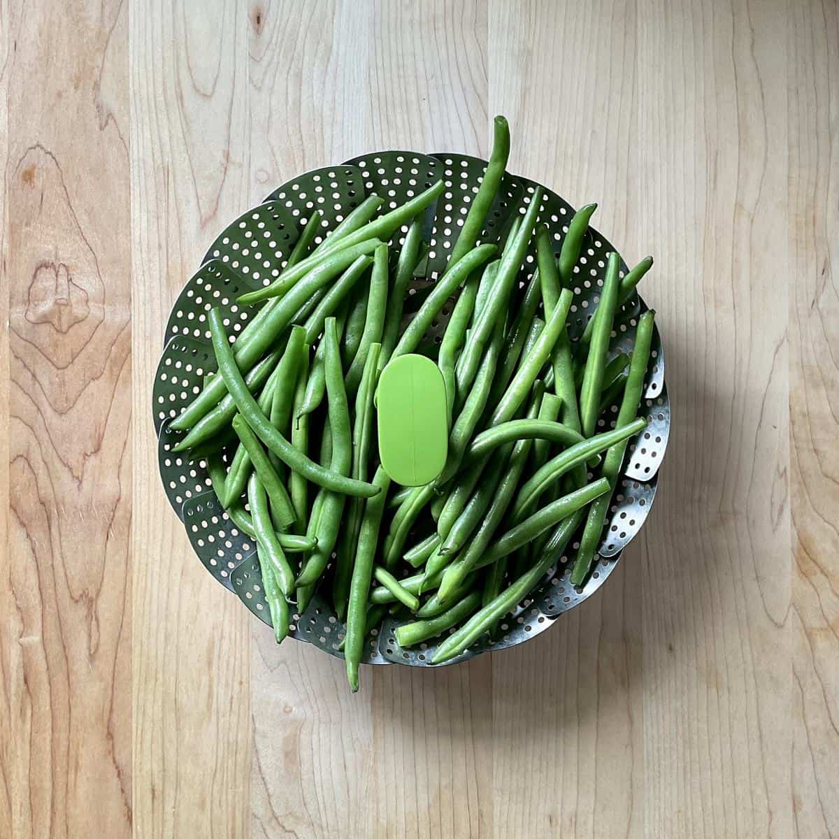 String beans in a steamer basket.