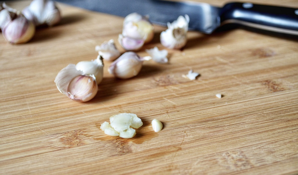 Crushed garlic on a wooden board.