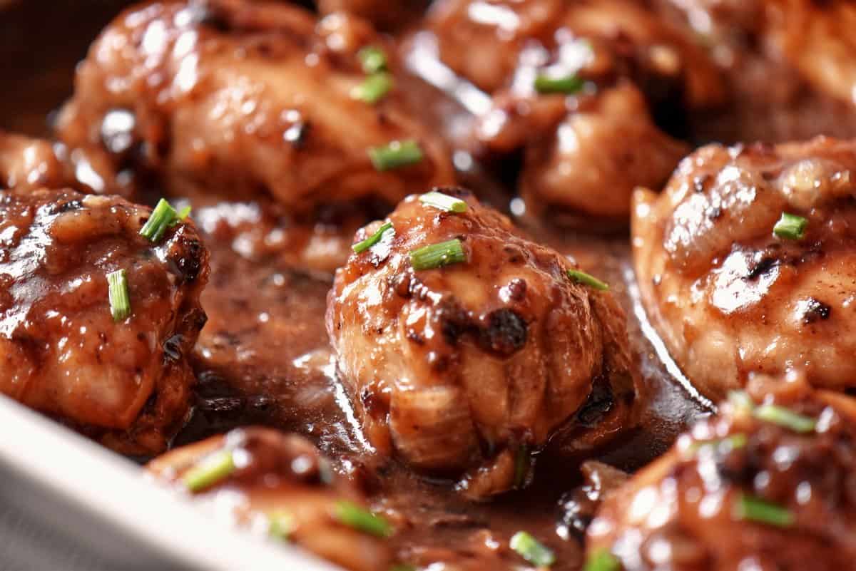 Boneless chicken thighs in a white baking dish.