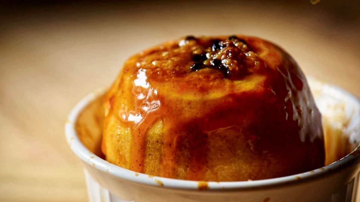 A glazed baked apple in a white dish.