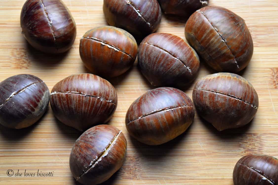 A few chestnuts with a clear vertical incision through the outer skin.