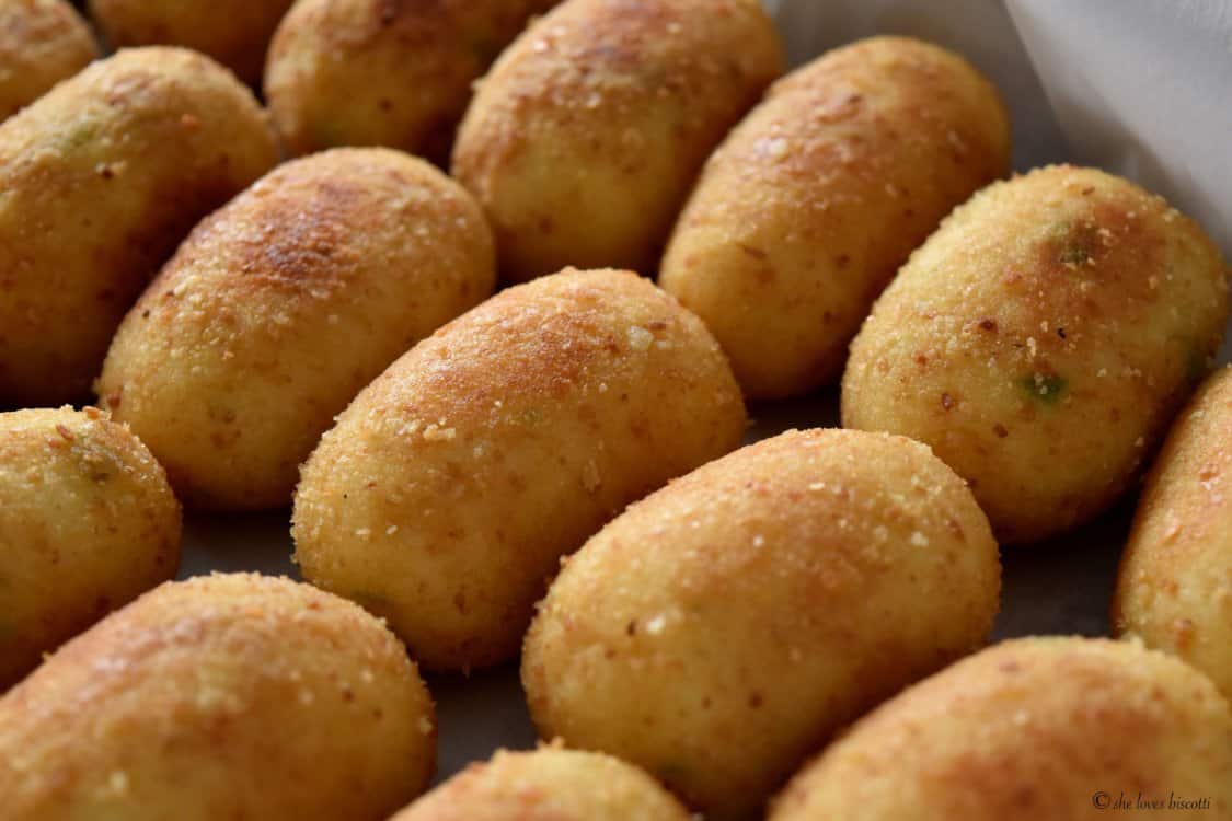 Pan fried potato croquettes in a platter.