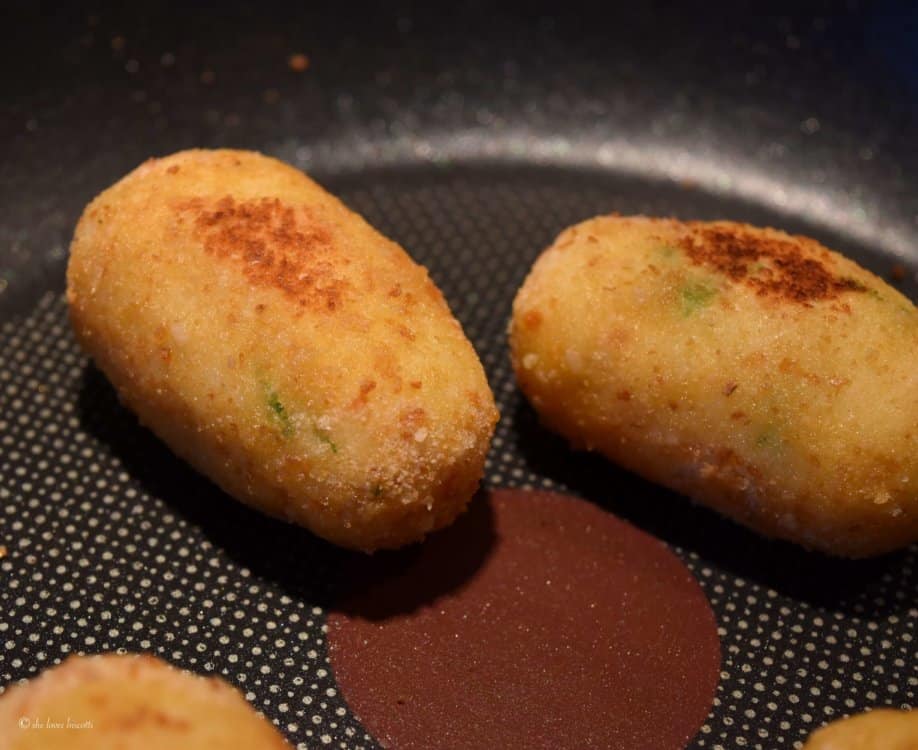 Potato croquettes being pan fried.