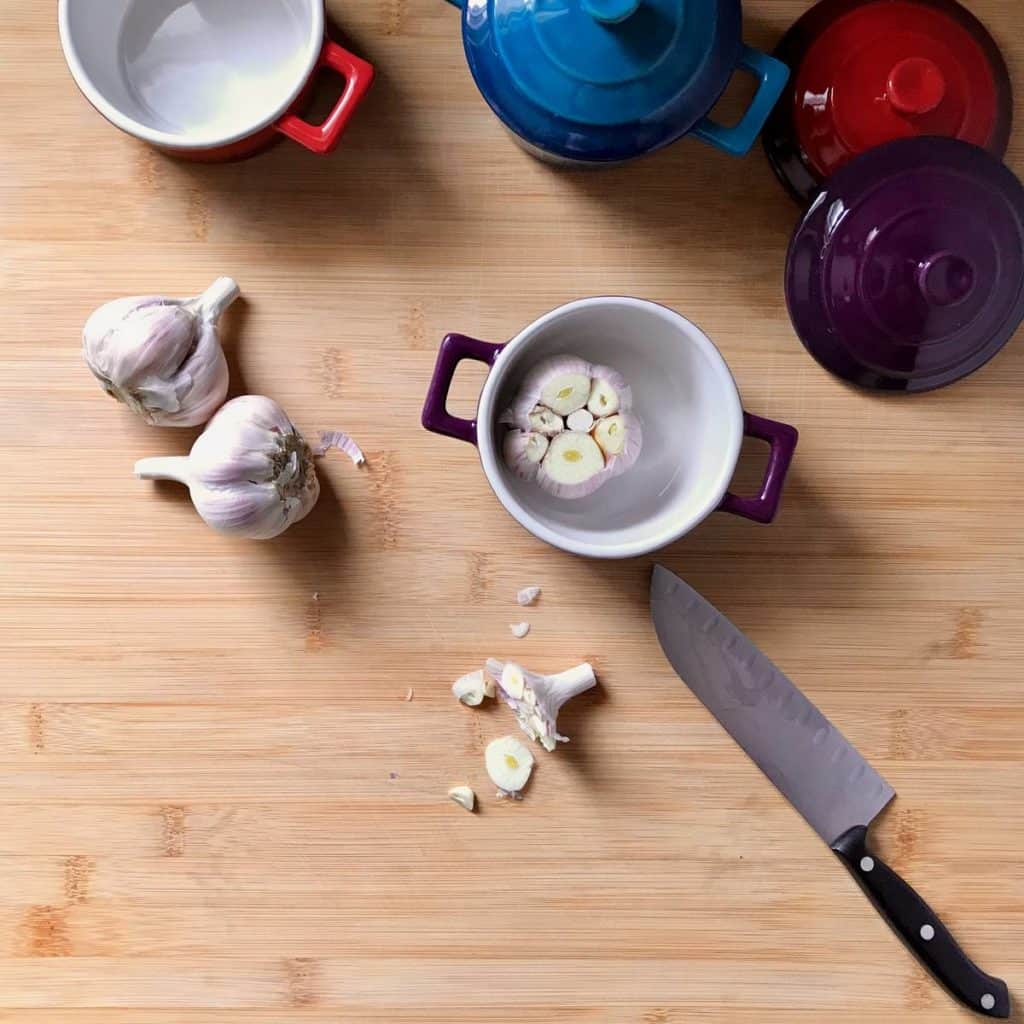 Garlic cloves placed in small ceramic dishes.