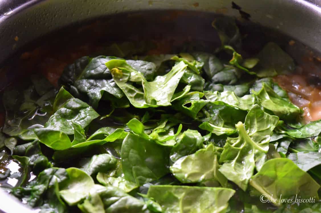 Spinach being added to the soup.