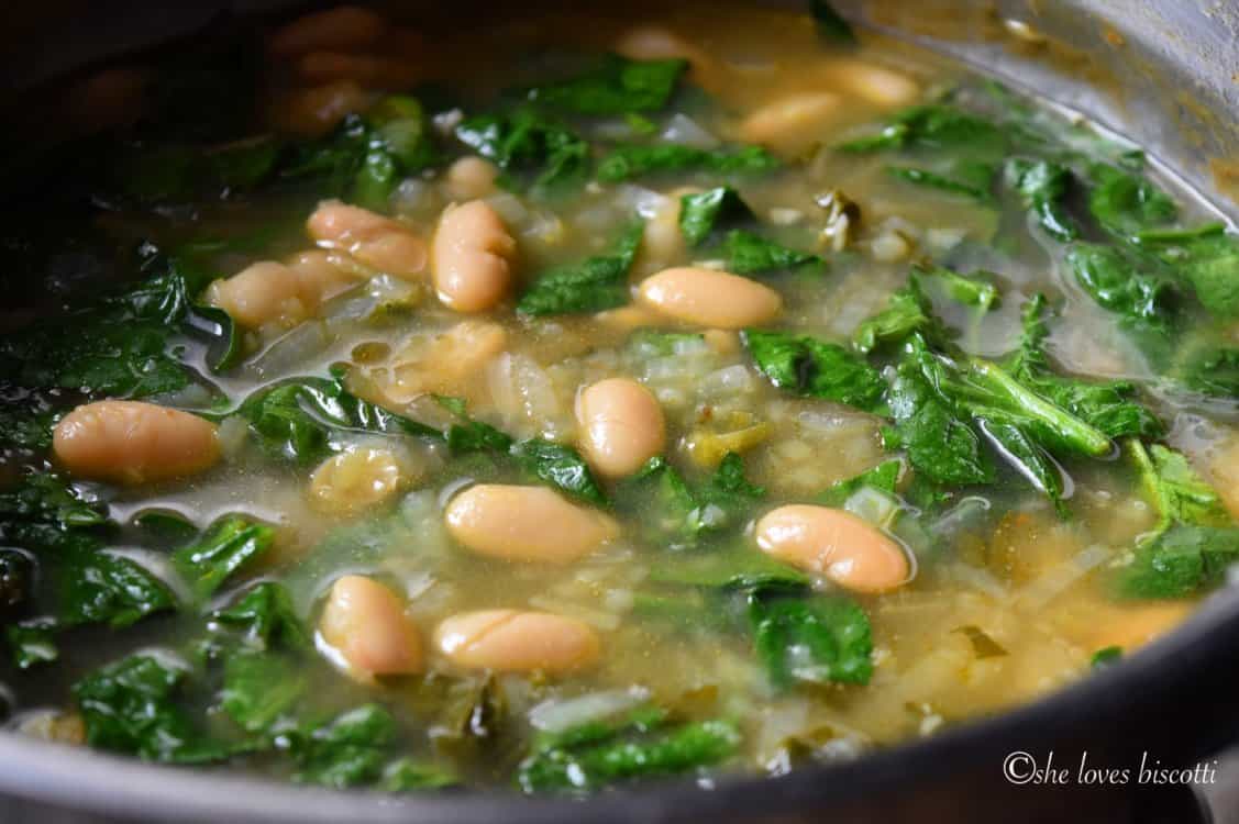 Easy White Kidney Bean and Spinach Soup simmering in a pot.