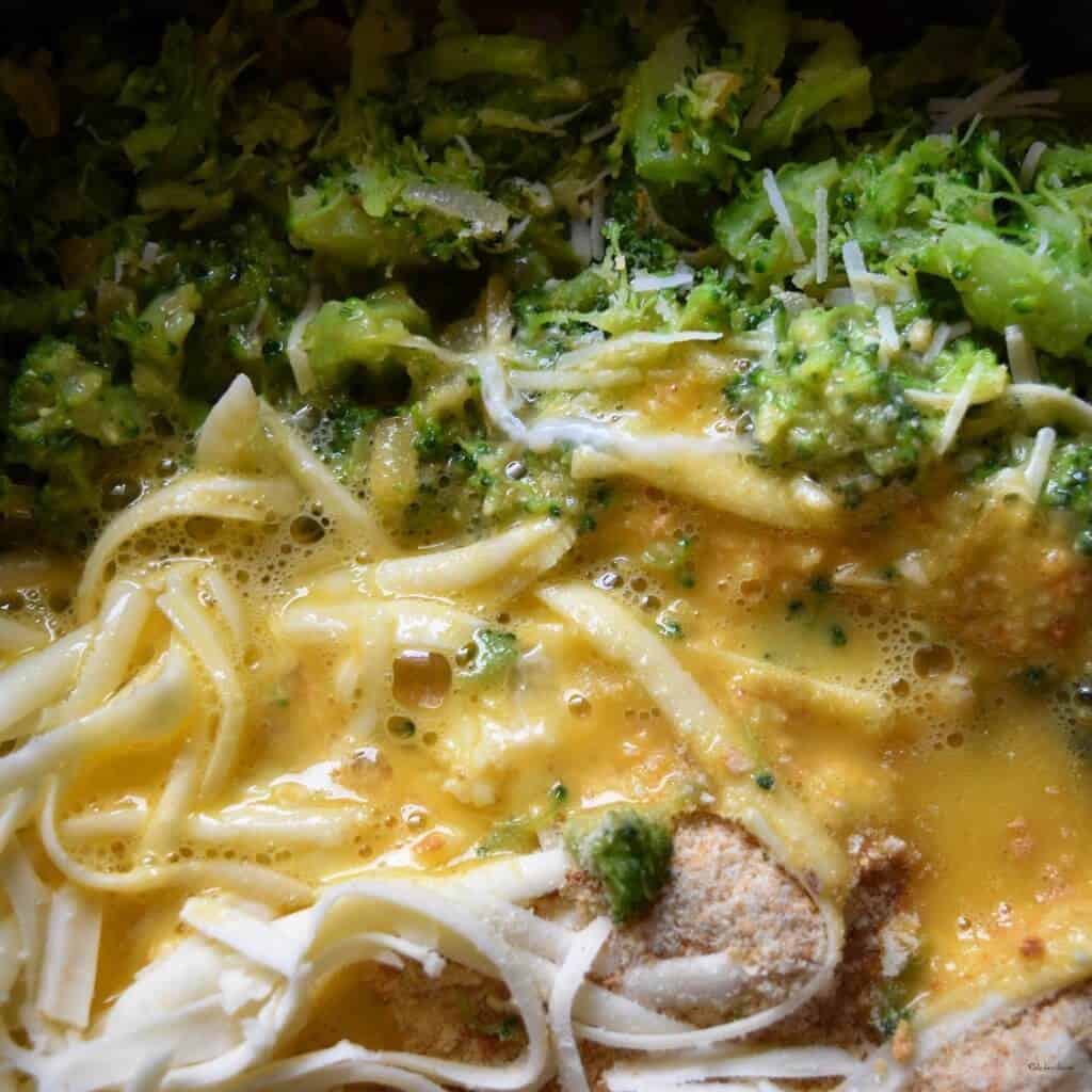 The addition of eggs and cheese to mashed broccoli. 