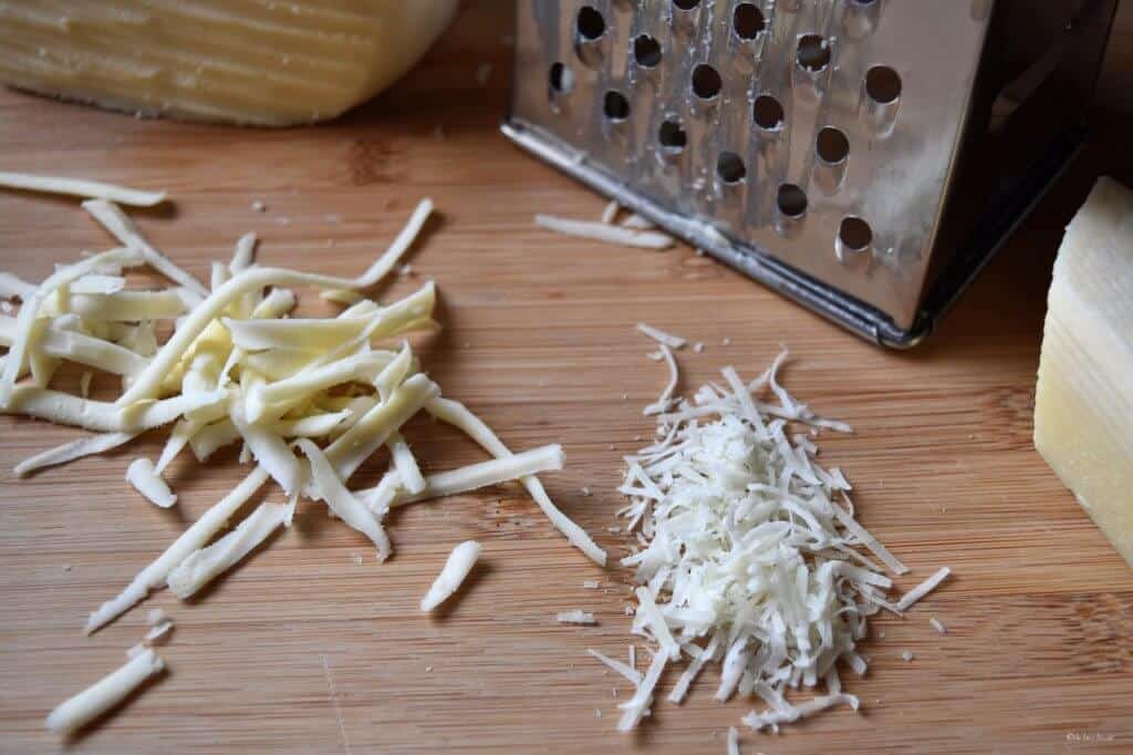 Grated cheeses on a wooden board. 