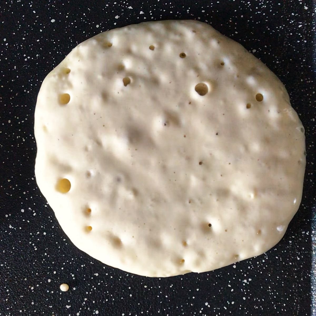 Air bubbles surfacing to the top of a pancake.