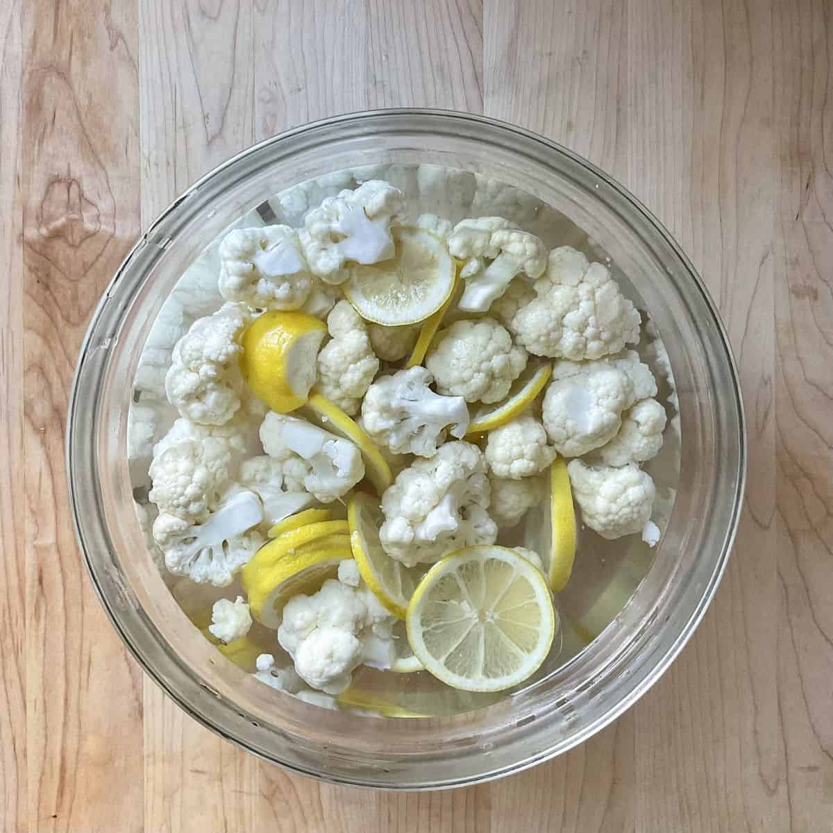 Cauliflower and lemon slices in a bowl.