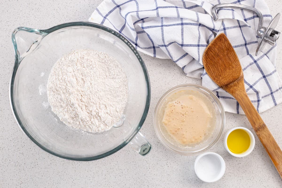 The ingredients to make this Italian pizza dough recipe are in bowls. 