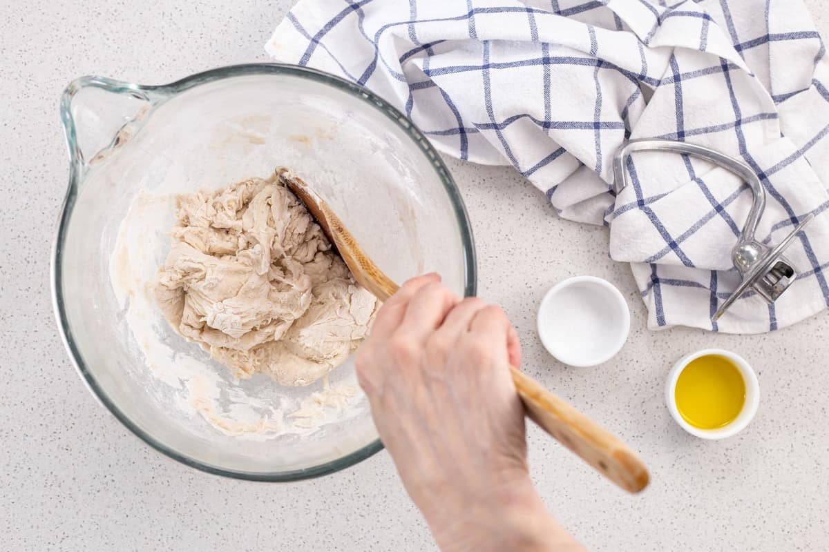 The yeast mixture is added to the flour and mixed together to obtain a "shaggy mass".