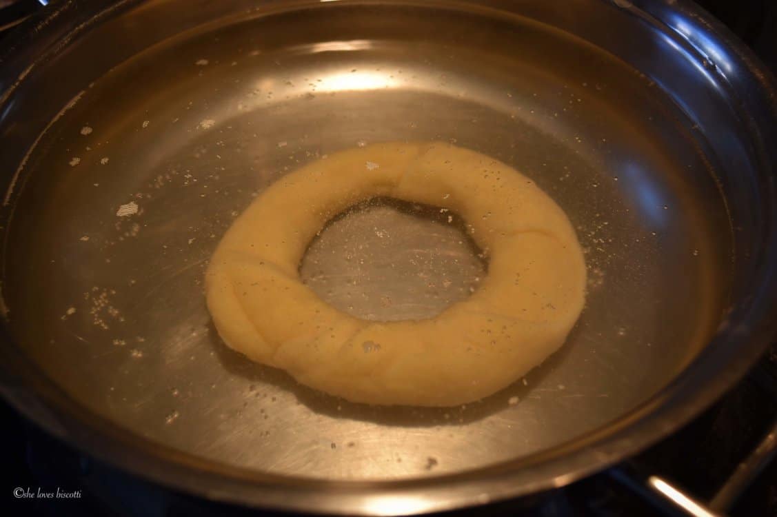 A pot of water with one taralli being boiled.