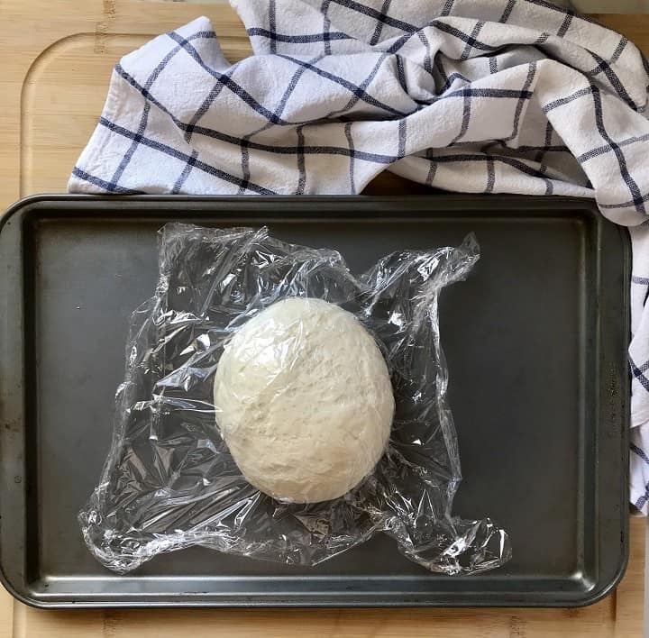 A ball of pizza dough on a sheet pan.