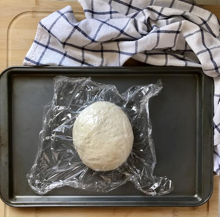 A ball of pizza dough on a sheet pan.