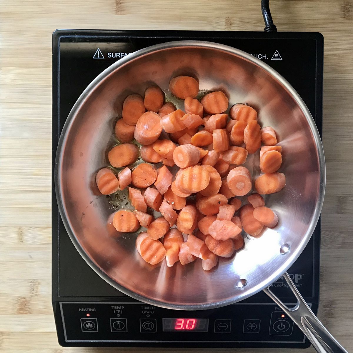 Carrots are sauteed in a large pan.