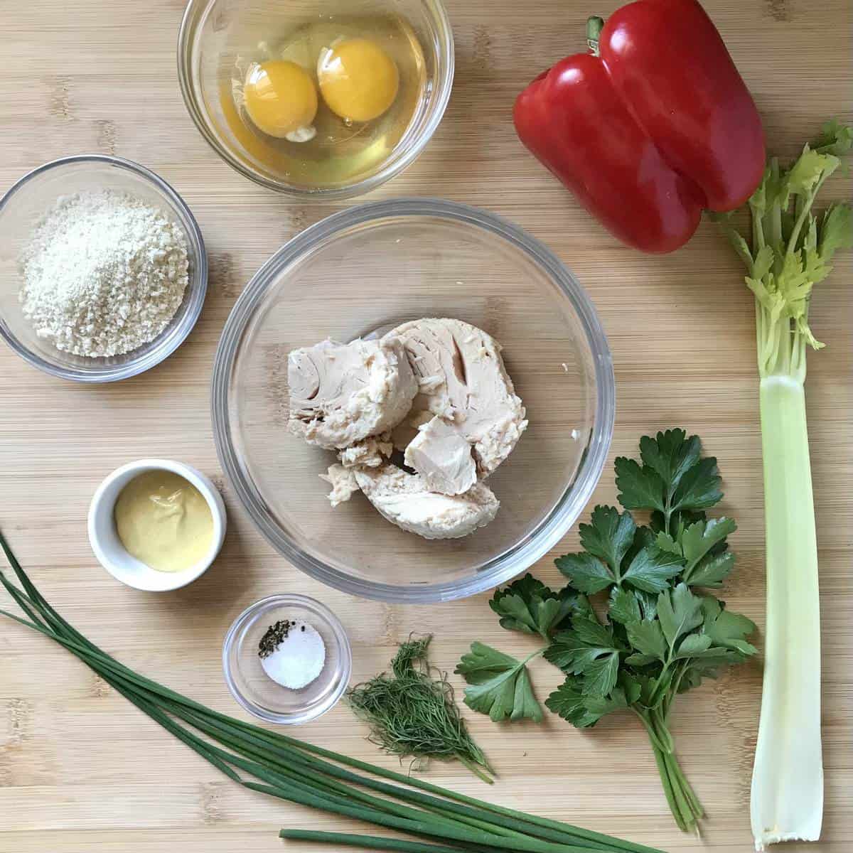 All the ingredients to make tuna croquettes on a wooden board.