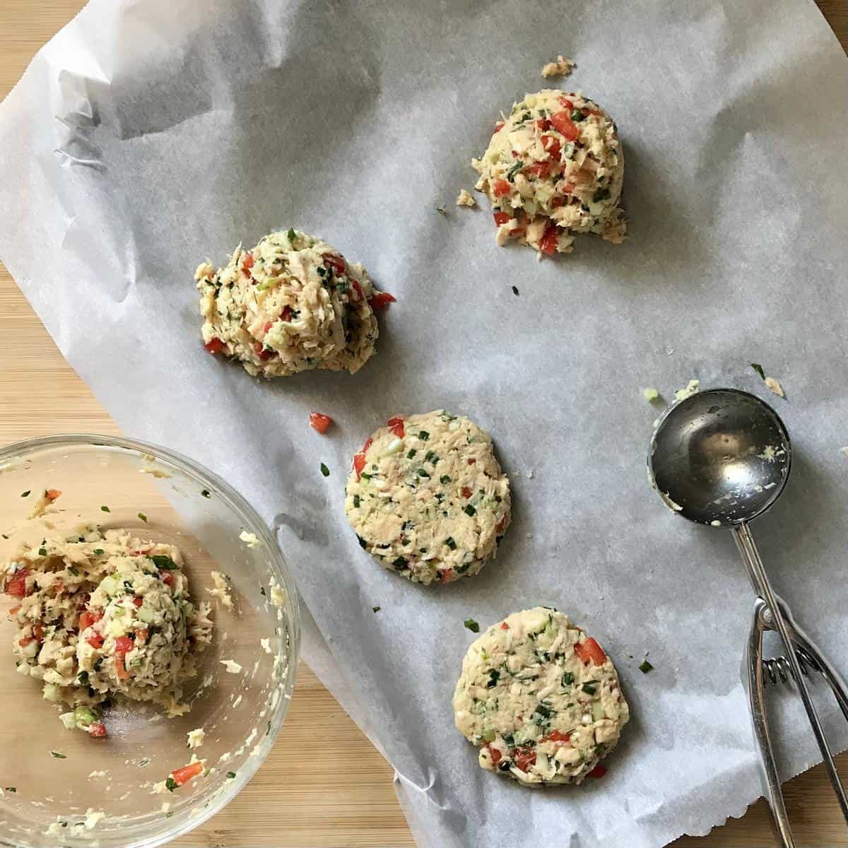 Tuna patties on a parchment lined sheetpan. 